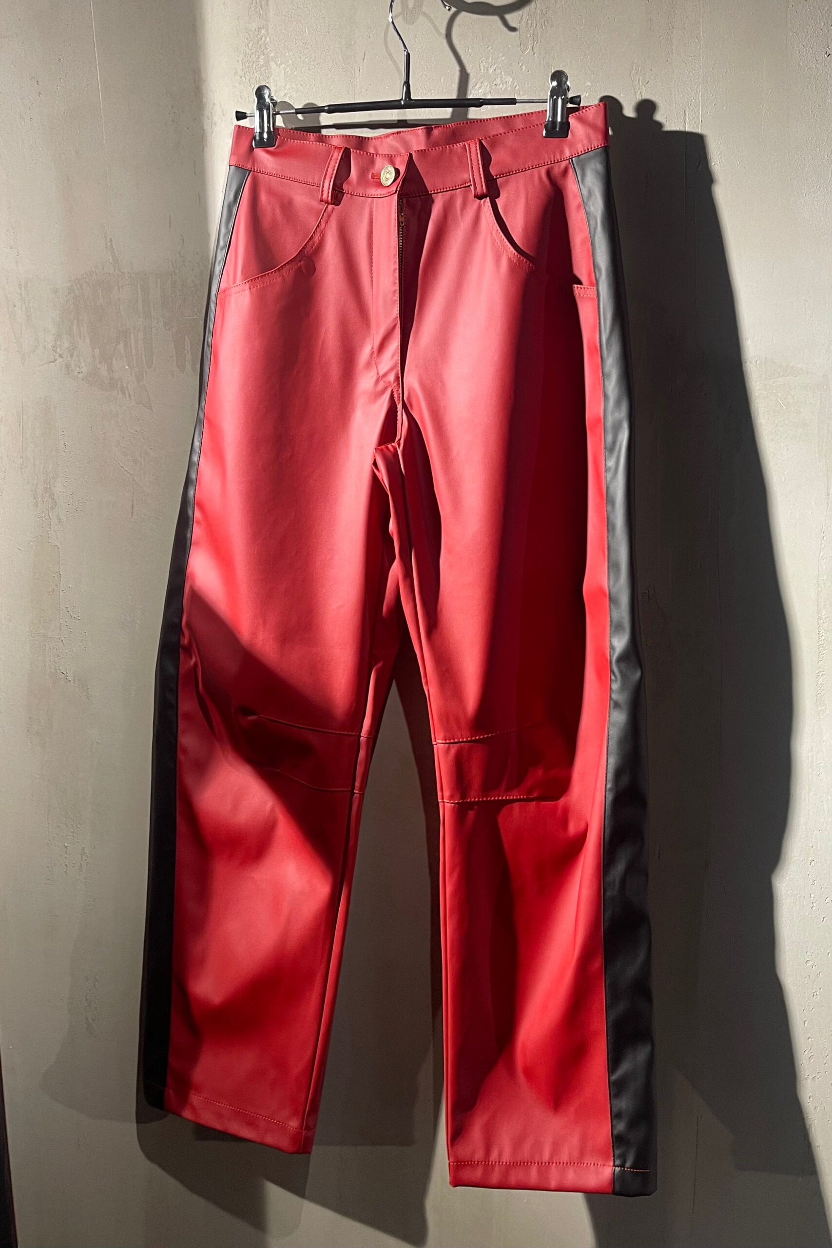 Pantalon ecocuero rojo con franja negra, pierna curva y tiro medio